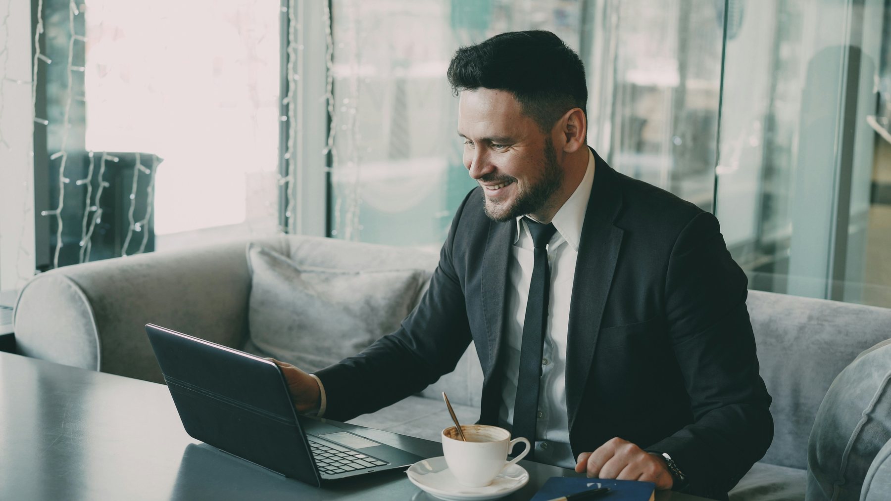 A smiling seller checking his payout report on a laptop